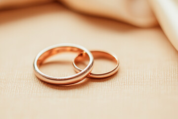 Wedding rings on a table in a wedding related environment symbolizing two people getting into a union.