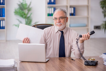 Old male employee working in the office