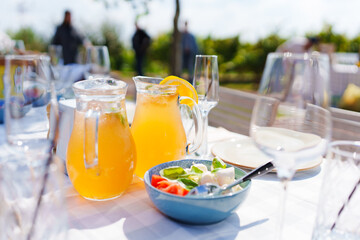 decanters with orange lemonade and vegetable salad with cheese 