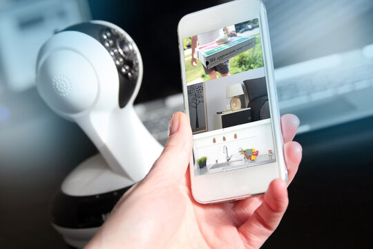 Woman monitoring modern cameras on smartphone indoors,  outdoors. Home security system