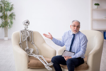 Old male psychologist meeting with skeleton