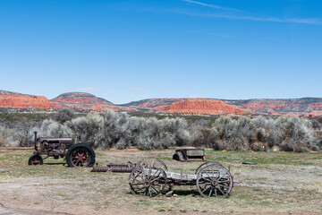 View of mountains with old wooden wagon and rusty tractor