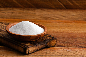 Saccharum officinarum - Refined white sugar in the wooden bowl