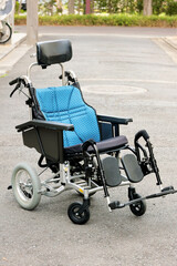 玄関前の路上に置かれた介護用リクライニング折り畳み車椅子　