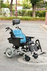 玄関前の路上に置かれた介護用リクライニング折り畳み車椅子　