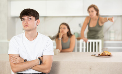 Upset guy dont speaking after discord with mother and young wife standing behind