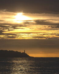 Fototapeta na wymiar La presqu'île du Cap Ferrat avec son phare près de Nice sur la Côte d'Azur dans les lueurs oranges d'un lever de soleil.