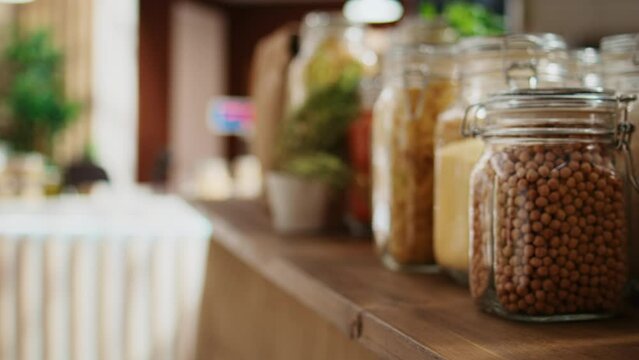 Close up shot of preservatives free pantry staples on zero waste supermarket shelves. Organic food in nonpolluting reusable glass containers on display in empty local neighborhood grocery store