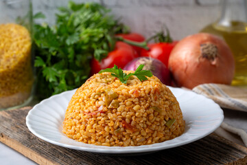Traditional turkish bulgur pilaf with tomato sause in plate (Turkish name; meyhane pilavi)
