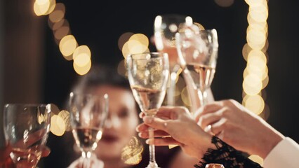 Stylish friends close up celebrating at glamorous merry Christmas new year birthday party making toast drinking champagne at formal social gathering enjoying evening celebration at Eve winter night.