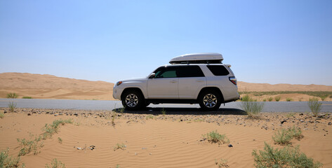 Inner Mongolia ,China - Circa 2021:  Driving White 2020 Toyota 4Runner TRD crossing in the desert...