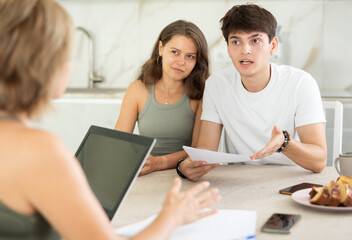 An insurance agent tells a young couple the terms of property and life insurance