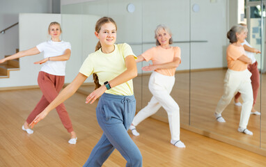 Obraz premium Girl dancing with her relatives during group aerobic training.
