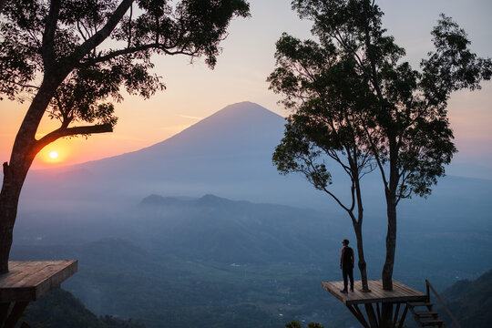 Silhouette of a man standing on the Lahangan Sweet viewpoint, overlooking Mount Agung, Bali island.