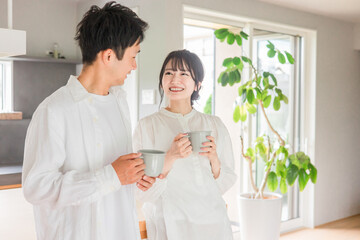家のダイニングでコーヒー・お茶・ホットドリンクを飲む夫婦・カップル
