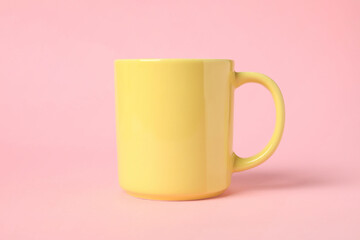 One yellow ceramic mug on pink background