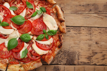 Delicious Caprese pizza on wooden table, top view. Space for text
