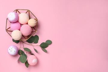 Bowl with bath bombs and eucalyptus leaves on pink background, flat lay. Space for text
