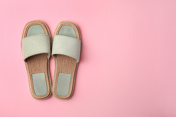 Pair of new slippers on pink background, flat lay. Space for text