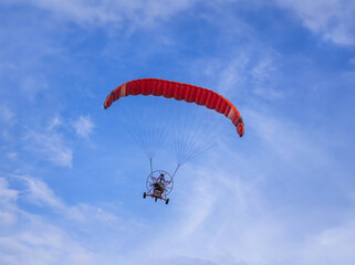 Paramotor or paragliding flying in the air on  blue  sky   - 667935567