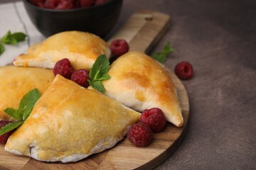 Delicious samosas with raspberries on grey table, closeup