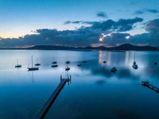 Sunrise blues over the bay with boats and clouds