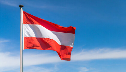 Naklejka premium Close up view of an Austria flag waving on a flagpole, with blue sky background and copy space