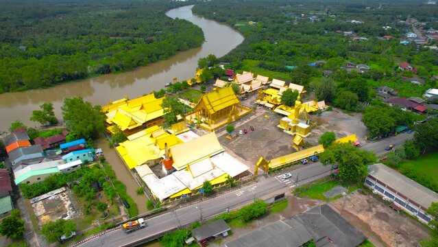 Wat Pak Nam Jolo in Chachoengsao, Thailand. Beautiful golden temple at rural Thailand with blue sky and cloud. View from Drone.
