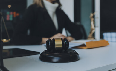 Judge gavel with Justice lawyers having team meeting at law firm in background. Concepts of law.