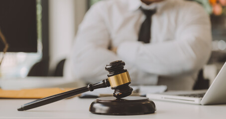 Judge gavel with Justice lawyers having team meeting at law firm in background. Concepts of law.