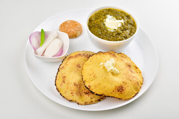 Saag with roti served with jaggery and salad in plate isolated on white background