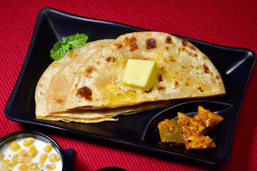 Stuffed paratha with butter and mango pickle, famous north indian breakfast 