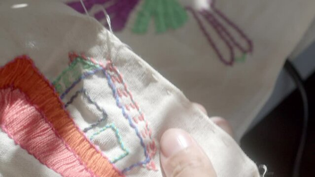 Hands doing delicate needlepoint - isolated close up craft