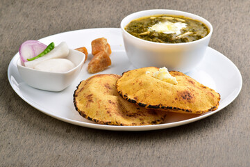 Traditional punjabi food sarson ka saag with makki ki roti served with jaggery and salad
