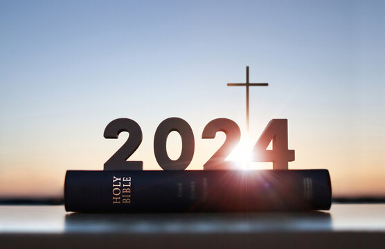 Brightly shining new year 2024, rising sun, sunrise and sunset background, cross of Jesus Christ, holy Bible, faith, belief and church calendar concept
