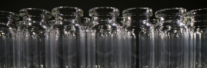Empty vials for vaccines stand in row on dark background