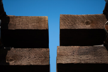 Closeup of a neat stack of materials for laying train tracks: railway sleepers (railroad ties) and steel rails are tidily arranged.