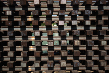 A stack of wooden beams and steel railroad tracks at a depot alongside a railroad route in California. The materials express themes of rail infrastructure, as well as a geometric array of commodities.