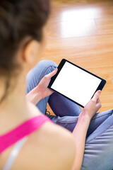 Digital png photo of woman sitting on floor and using tablet, copy space on transparent background