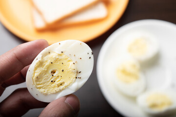 Slice of boiled egg in hand