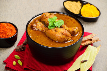 Indian style spicy chicken curry in bowl, whole spices