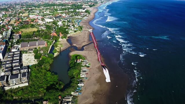 Traditional Janggan kite with long tail soaring high above coast, Bali.