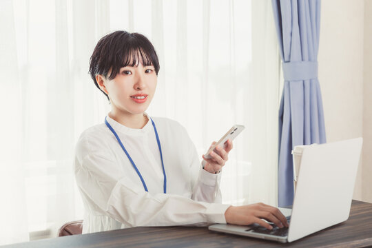 スマホとPCを操作する女性　　business Operate smartphone and PC