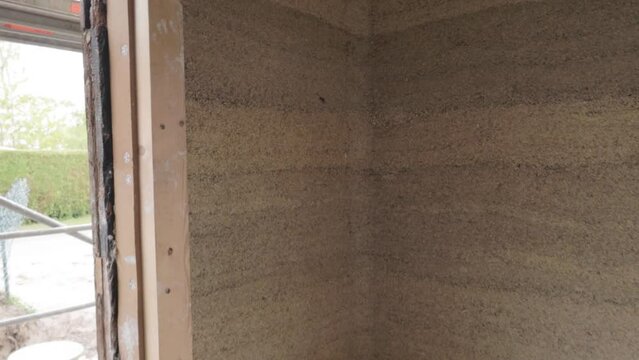 Inside tilt down view of a hempcrete wall corner in wooden frame unter construction