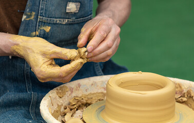 Clay craftsman sculpts crockery . Close-up.