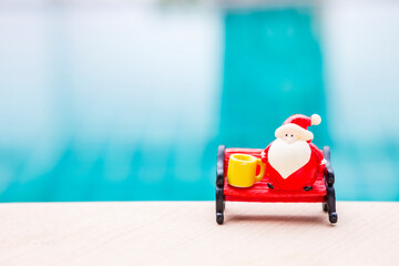 Christmas background idea, Santa claus on red bench with yellow coffee cup over blurred background,...