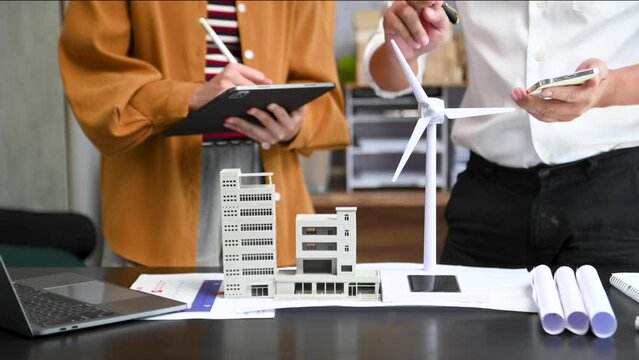 Business people having consultation about wind energy at company office. Business team discussing about windmill and alternative green enery. Executive meeting .
