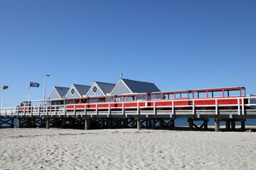 Historical pier in Busselton, Western Australia.  Showing pier, train, buildings, ocean and blue sky