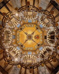 Ornately decorated domed ceiling with gold-painted accents inside the Aachen Cathedral in Germany