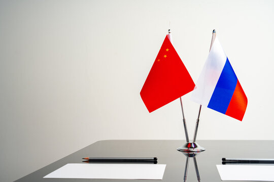 Russian and Chinese flags on negotiation table